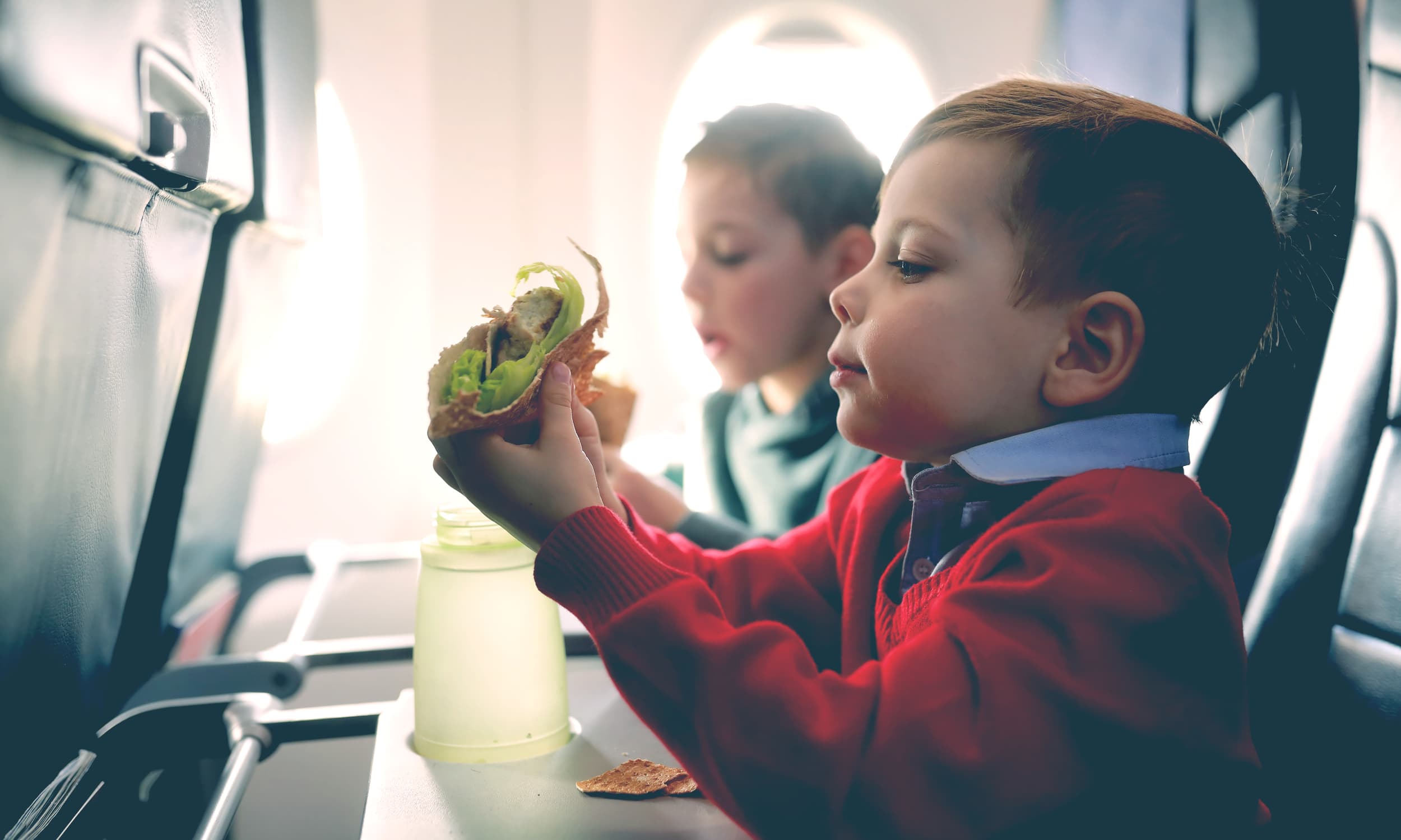 little kid eat in a plane